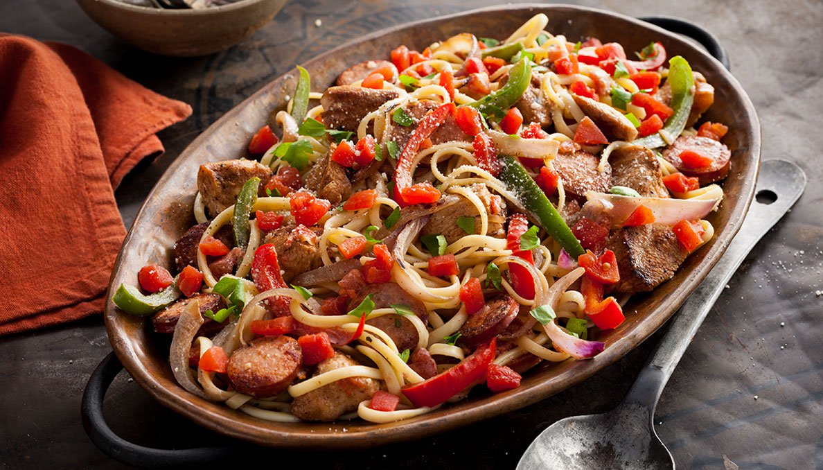 Image of Cajun Chicken Pasta on oval platter diced tomatoes sliced green peppers and spaghetti