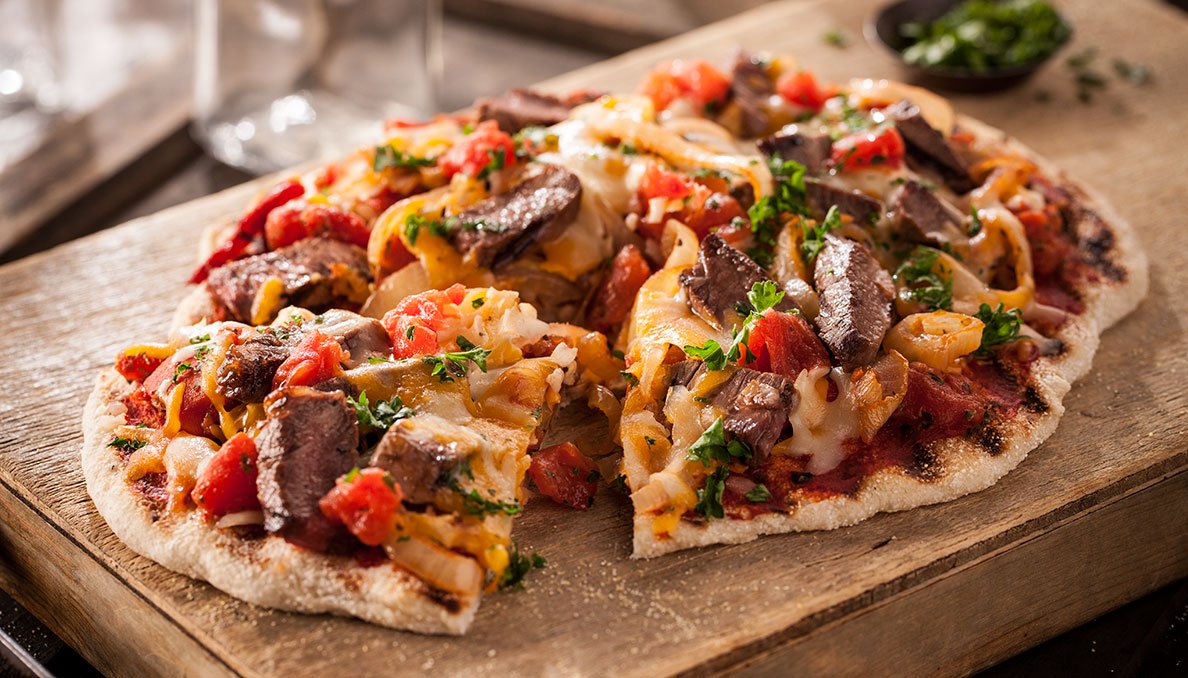 Image of Grilled Cheesesteak Pizza slice cut and pulled away from pizza