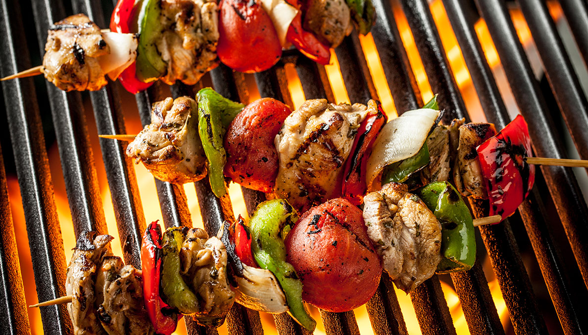 Image of Grilled Chicken Fajita Skewers over grill with flames beneath using whole peeled tomatoes