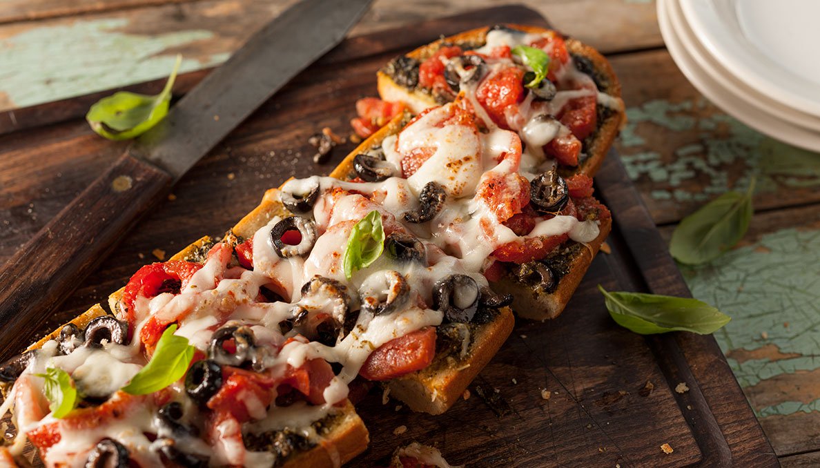 Plum Tomato Pesto Bread with olives diced tomatoes and melted cheese
