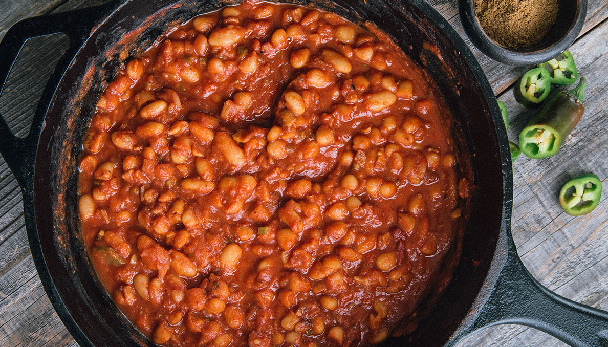 Image of Redneck Riviera BBQ Baked Beans in cast iron skillet