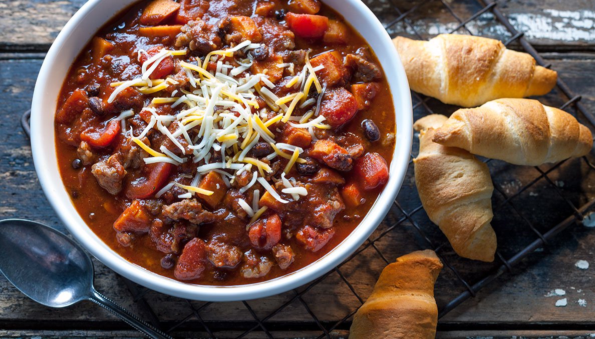 Image of Sausage sweet potato chili in bowl crescent rolls