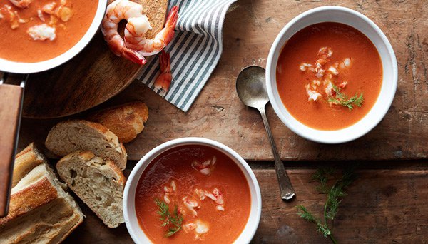 Image of three bowls of shrimp and tomato bisque in white bowls with shrimp and bread slices