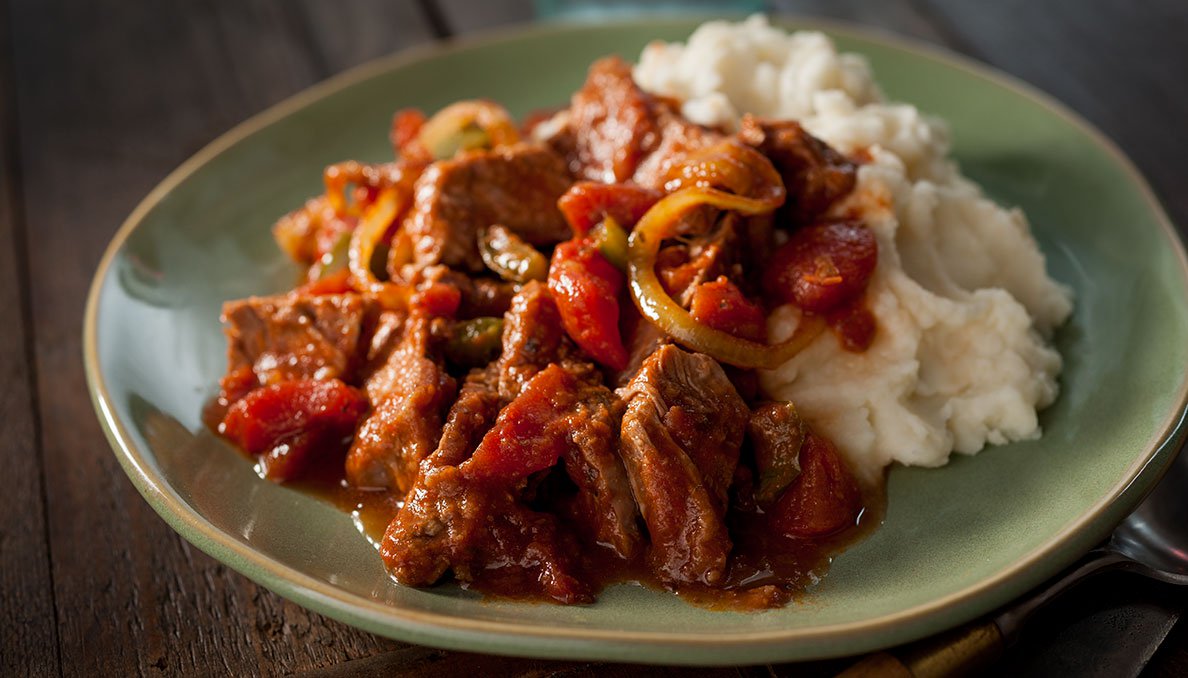 Image of Slow Cooker Swiss Steak with mashed potatoes on green plate