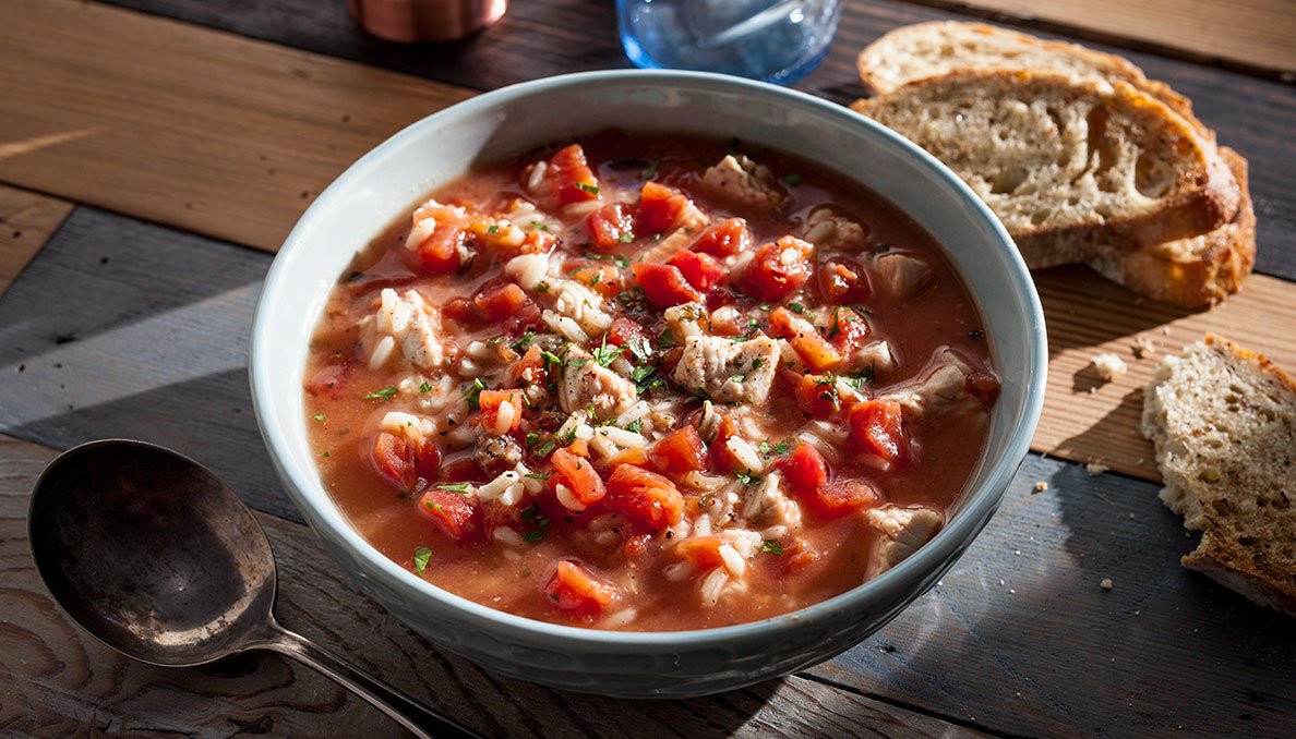 Image of Turkey rice soup in a bowl with sliced bread
