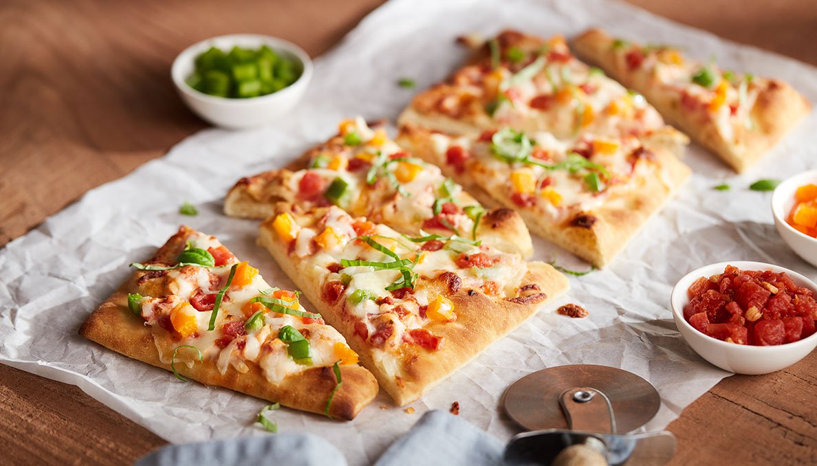 Image of Veggie Flatbread PIzza cut into slices with bell peppers pizza cutter and petite diced tomatoes