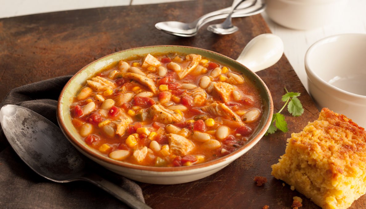 Image of a bowl of white chicken chili and corn bread